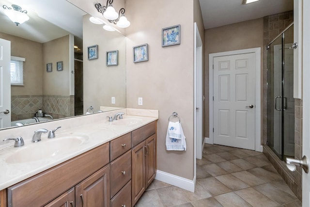 bathroom with a shower stall, tile patterned flooring, double vanity, and a sink