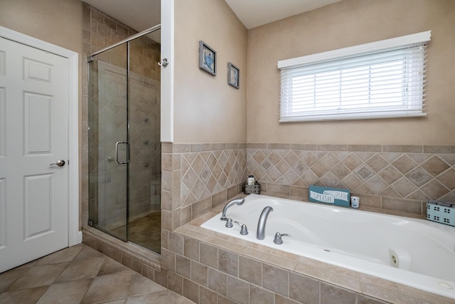 full bath featuring tile patterned floors, a stall shower, and a garden tub