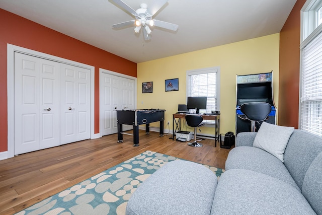 office area with baseboards, wood finished floors, and ceiling fan
