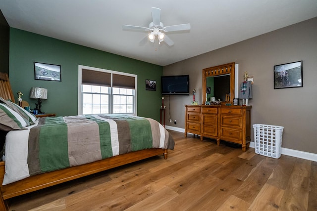 bedroom featuring wood finished floors, a ceiling fan, and baseboards