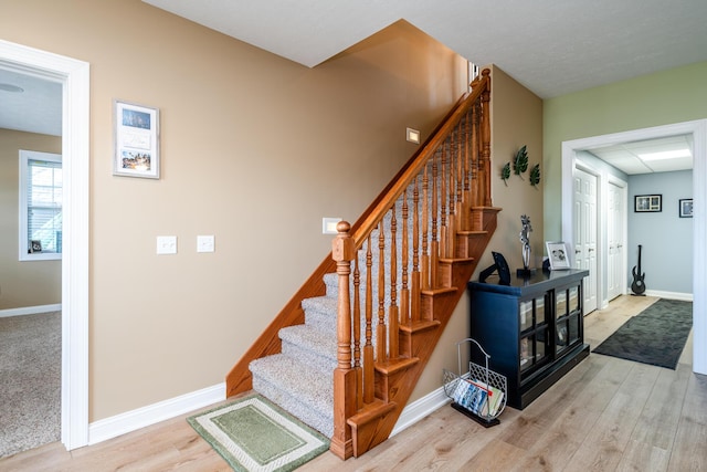 stairway featuring baseboards and wood finished floors