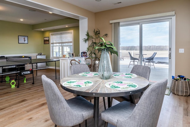 dining area featuring light wood-style floors, visible vents, and baseboards