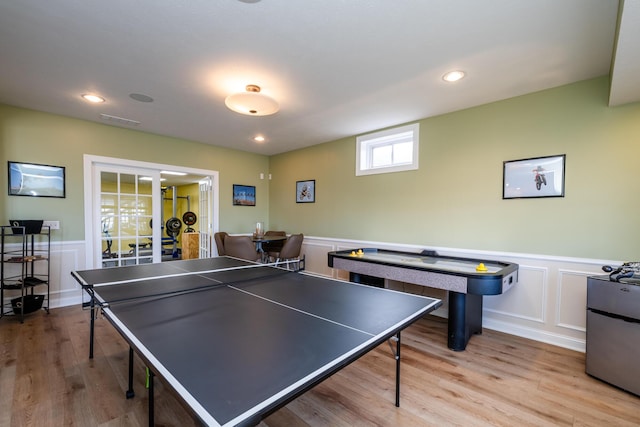 playroom with a decorative wall, visible vents, and wainscoting