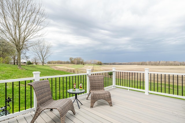 wooden deck featuring a rural view and a lawn