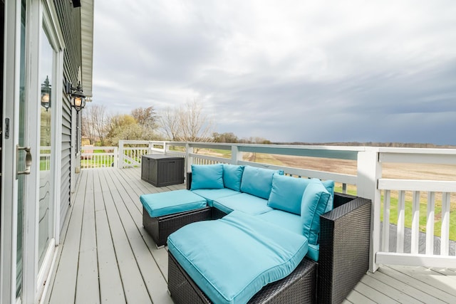 wooden deck featuring an outdoor living space and a water view