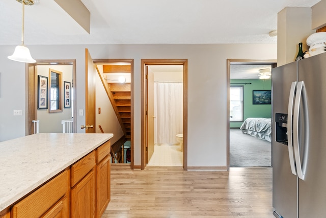 10951 N Waldron Rd, Jerome, MI 49249 - kitchen featuring baseboards, stainless steel refrigerator with ice dispenser, light wood-style floors, and pendant lighting