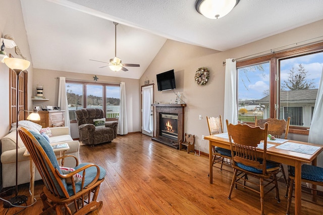 66100 Dolans Ave, Vandalia, MI 49095 - dining room featuring wood-type flooring, vaulted ceiling, a glass covered fireplace, and ceiling fan