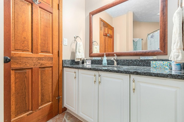 66100 Dolans Ave, Vandalia, MI 49095 - bathroom with a textured ceiling, tile patterned flooring, and vanity