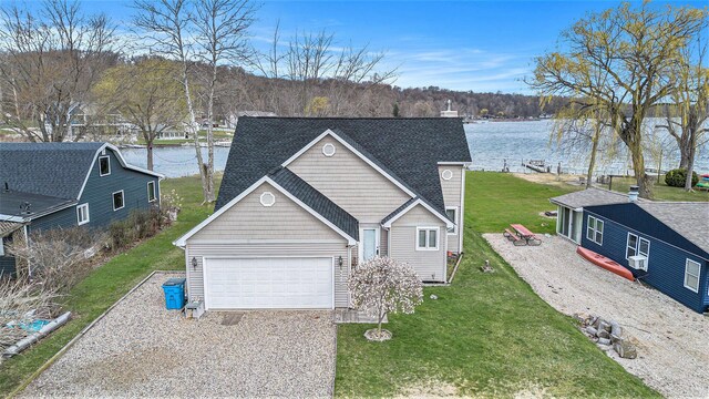 66100 Dolans Ave, Vandalia, MI 49095 - traditional home featuring a garage, gravel driveway, a water view, and a front lawn
