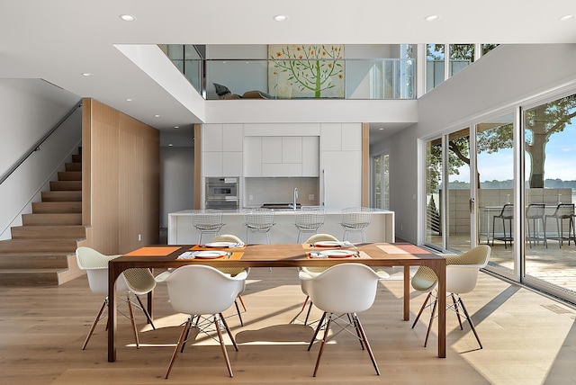 602 Lawn Ave, Holland, MI 49424 - dining room featuring recessed lighting, stairway, a towering ceiling, visible vents, and light wood-style floors