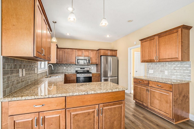 8560 Western Woods Dr, Kalamazoo, MI 49009 - kitchen with a sink, brown cabinets, appliances with stainless steel finishes, a peninsula, and dark wood-style flooring