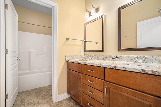 8560 Western Woods Dr, Kalamazoo, MI 49009 - full bathroom with double vanity, baseboards, shower / tub combination, and a sink