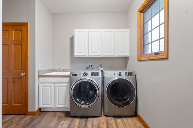 2776 W Hogan Dr, La Porte, IN 46350 - laundry room with cabinet space, washing machine and dryer, baseboards, light wood-style floors, and a textured ceiling