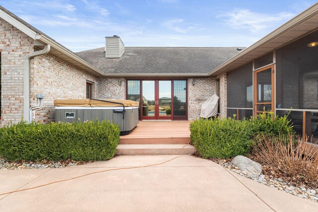 2776 W Hogan Dr, La Porte, IN 46350 - doorway to property featuring a hot tub, brick siding, a chimney, and a shingled roof