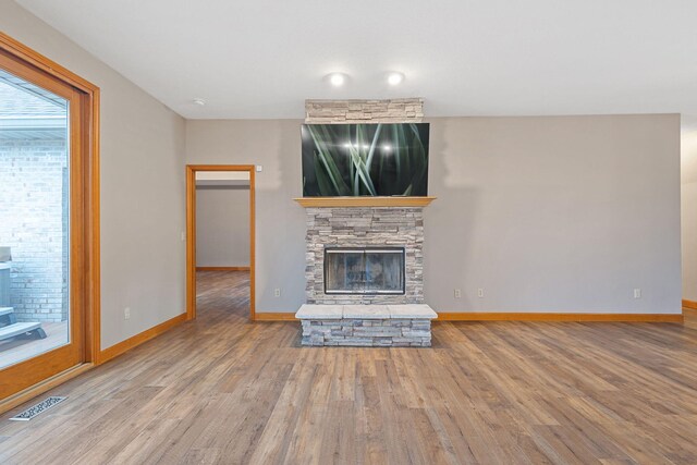 2776 W Hogan Dr, La Porte, IN 46350 - unfurnished living room with a stone fireplace, wood finished floors, and baseboards