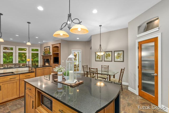 17180 Shore Oaks W Ln, Holland, MI 49424 - kitchen featuring built in microwave, stone tile floors, a kitchen island, recessed lighting, and decorative light fixtures