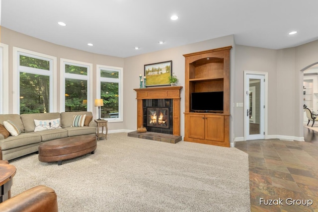 17180 Shore Oaks W Ln, Holland, MI 49424 - living area featuring a fireplace, arched walkways, recessed lighting, and dark stone finish floors