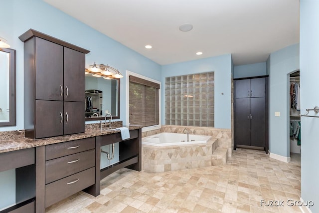 17180 Shore Oaks W Ln, Holland, MI 49424 - bathroom featuring a bath, vanity, a spacious closet, and recessed lighting