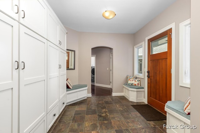 17180 Shore Oaks W Ln, Holland, MI 49424 - mudroom featuring arched walkways, stone finish flooring, and washer / clothes dryer