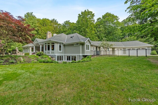 17180 Shore Oaks W Ln, Holland, MI 49424 - back of house featuring a chimney and an attached garage
