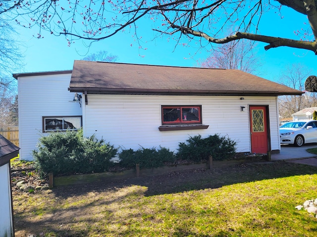 view of front of property with a front yard and roof with shingles