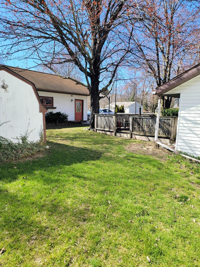 view of yard with a storage shed, a deck, and an outdoor structure