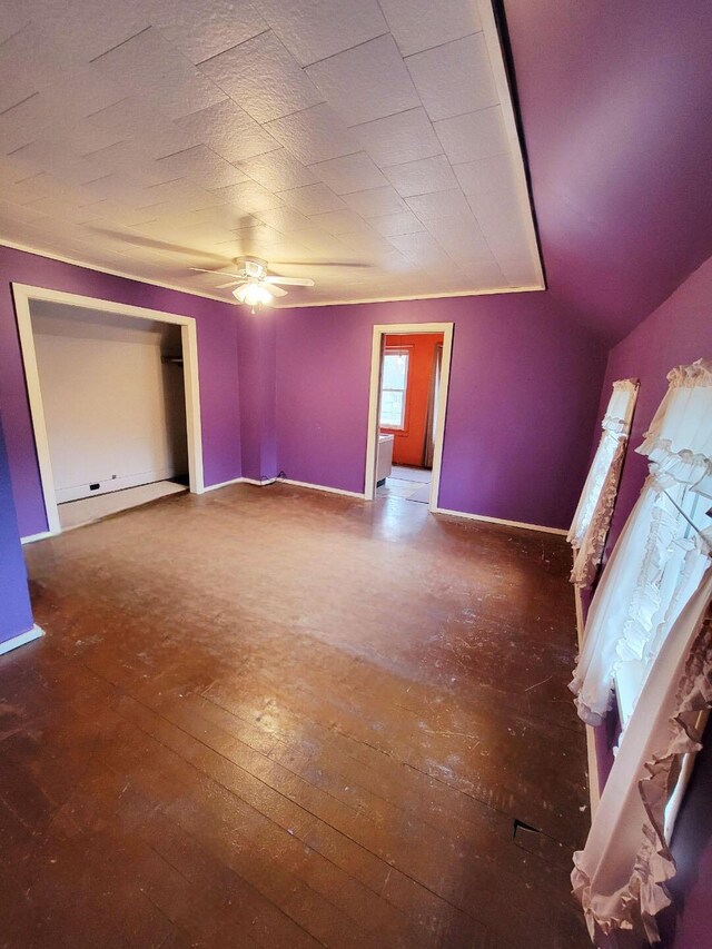 unfurnished bedroom with a ceiling fan, hardwood / wood-style floors, and baseboards