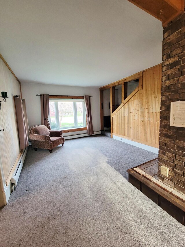living room with wooden walls, carpet flooring, and a baseboard radiator