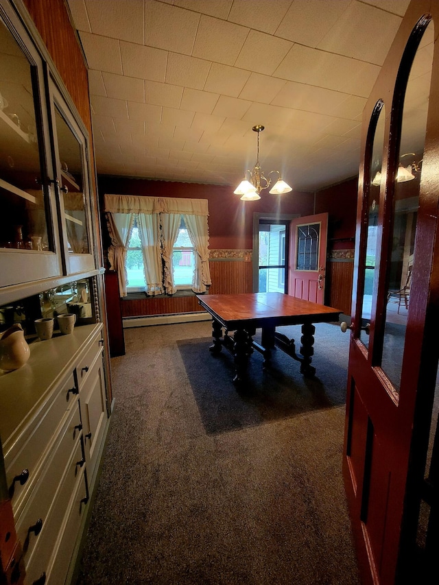 dining area featuring wainscoting, a baseboard heating unit, carpet floors, and an inviting chandelier