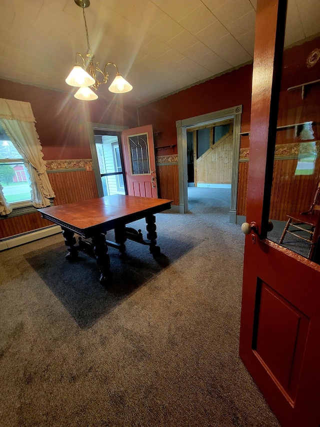dining area with a baseboard radiator, a healthy amount of sunlight, carpet flooring, and a notable chandelier
