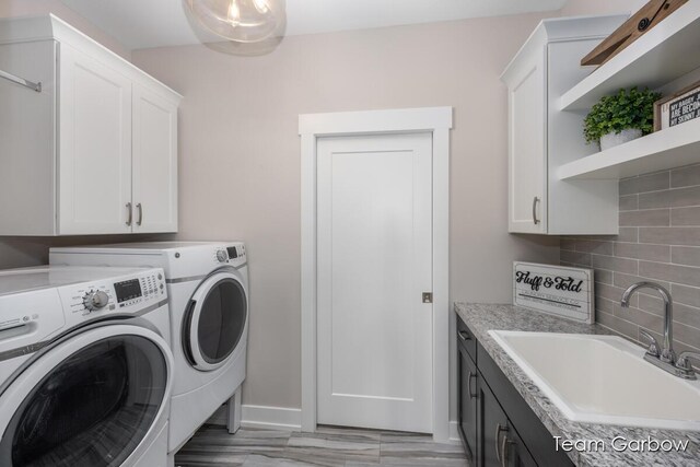 8393 Woodhaven Dr SW Unit 01, Byron Center, MI 49315 - laundry area with baseboards, a sink, independent washer and dryer, and cabinet space