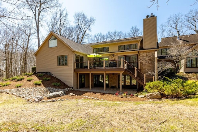 rear view of house with a chimney, stairway, and a deck