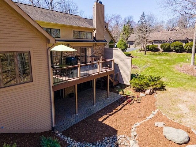 rear view of property featuring a chimney and a deck