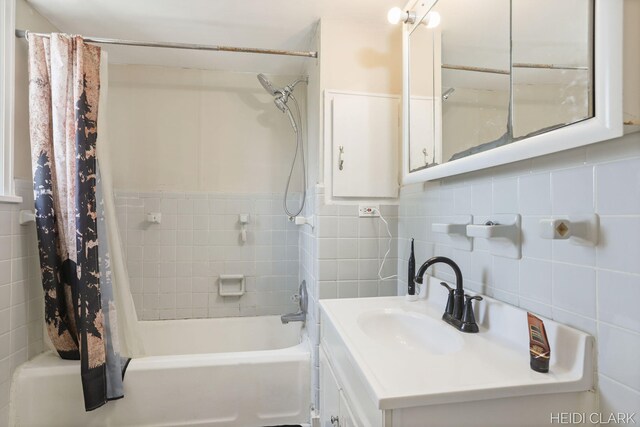 3552 47th St, Hamilton, MI 49419 - full bathroom featuring tile walls, shower / bath combo with shower curtain, decorative backsplash, and vanity