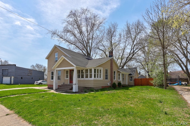 3552 47th St, Hamilton, MI 49419 - bungalow-style home with fence, roof with shingles, a chimney, and a front yard