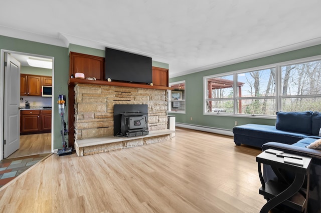 419 Larkspur Ave, Portage, MI 49002 - living area featuring light wood-style flooring, baseboards, baseboard heating, a wood stove, and ornamental molding