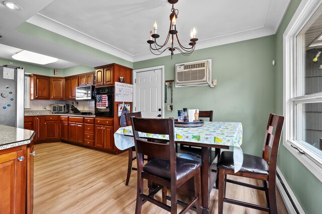 419 Larkspur Ave, Portage, MI 49002 - dining space featuring a chandelier, light wood-type flooring, an AC wall unit, and baseboard heating