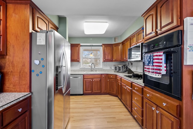 419 Larkspur Ave, Portage, MI 49002 - kitchen featuring light wood-style flooring, brown cabinetry, a sink, and black appliances