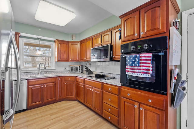 419 Larkspur Ave, Portage, MI 49002 - kitchen with brown cabinetry, black appliances, and a sink