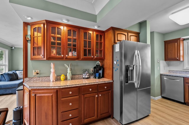 419 Larkspur Ave, Portage, MI 49002 - kitchen with light wood-style flooring, baseboards, glass insert cabinets, light stone counters, and appliances with stainless steel finishes