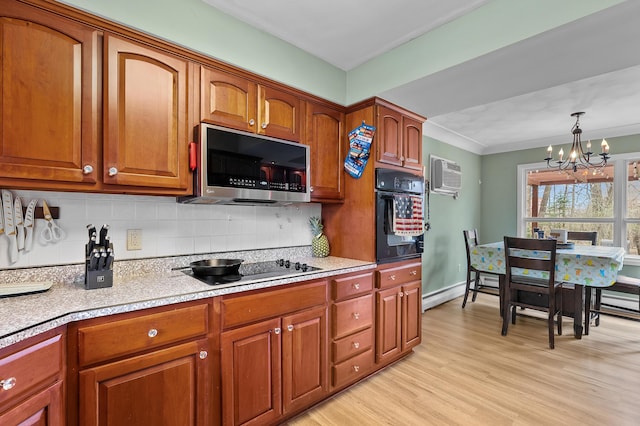 419 Larkspur Ave, Portage, MI 49002 - kitchen featuring tasteful backsplash, a notable chandelier, brown cabinets, light countertops, and black appliances