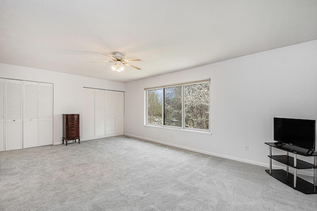 2420 E Collier Ave SE, Grand Rapids, MI 49546 - unfurnished bedroom with baseboards, ceiling fan, carpet floors, and multiple closets
