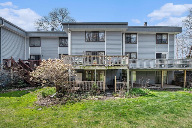 2420 E Collier Ave SE, Grand Rapids, MI 49546 - rear view of property featuring a lawn, a deck, and an attached garage