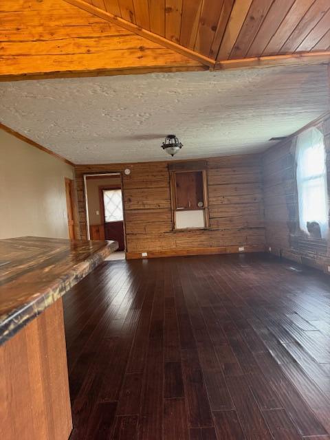314 W Main, Whitehall, MI 49461 - unfurnished living room with crown molding, wood walls, and dark wood finished floors