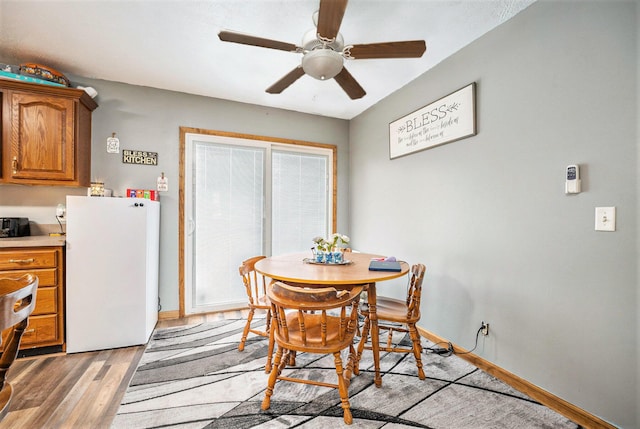 103 S Leeth St, White Pigeon, MI 49099 - dining room with light wood finished floors, a ceiling fan, and baseboards