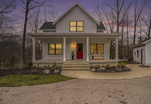 bungalow-style home with a porch and a shingled roof