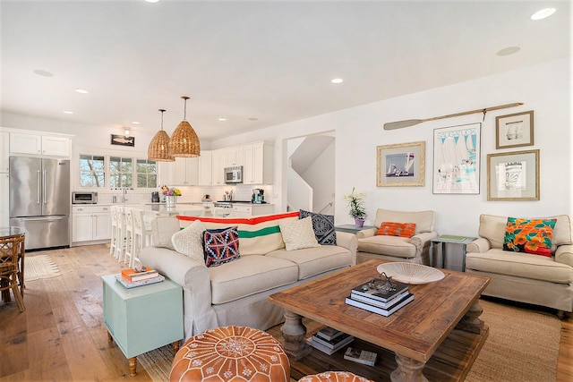 living area with recessed lighting, light wood-style flooring, and a toaster