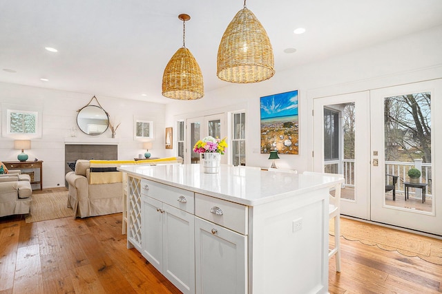 kitchen featuring light countertops, a kitchen island, light wood finished floors, and french doors