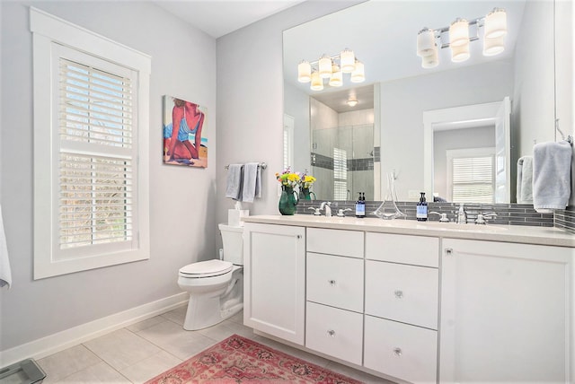 full bathroom featuring a sink, double vanity, toilet, baseboards, and a shower stall