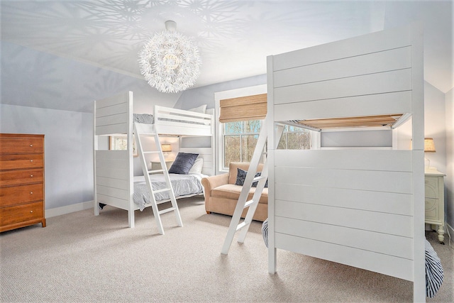 carpeted bedroom featuring baseboards and a notable chandelier